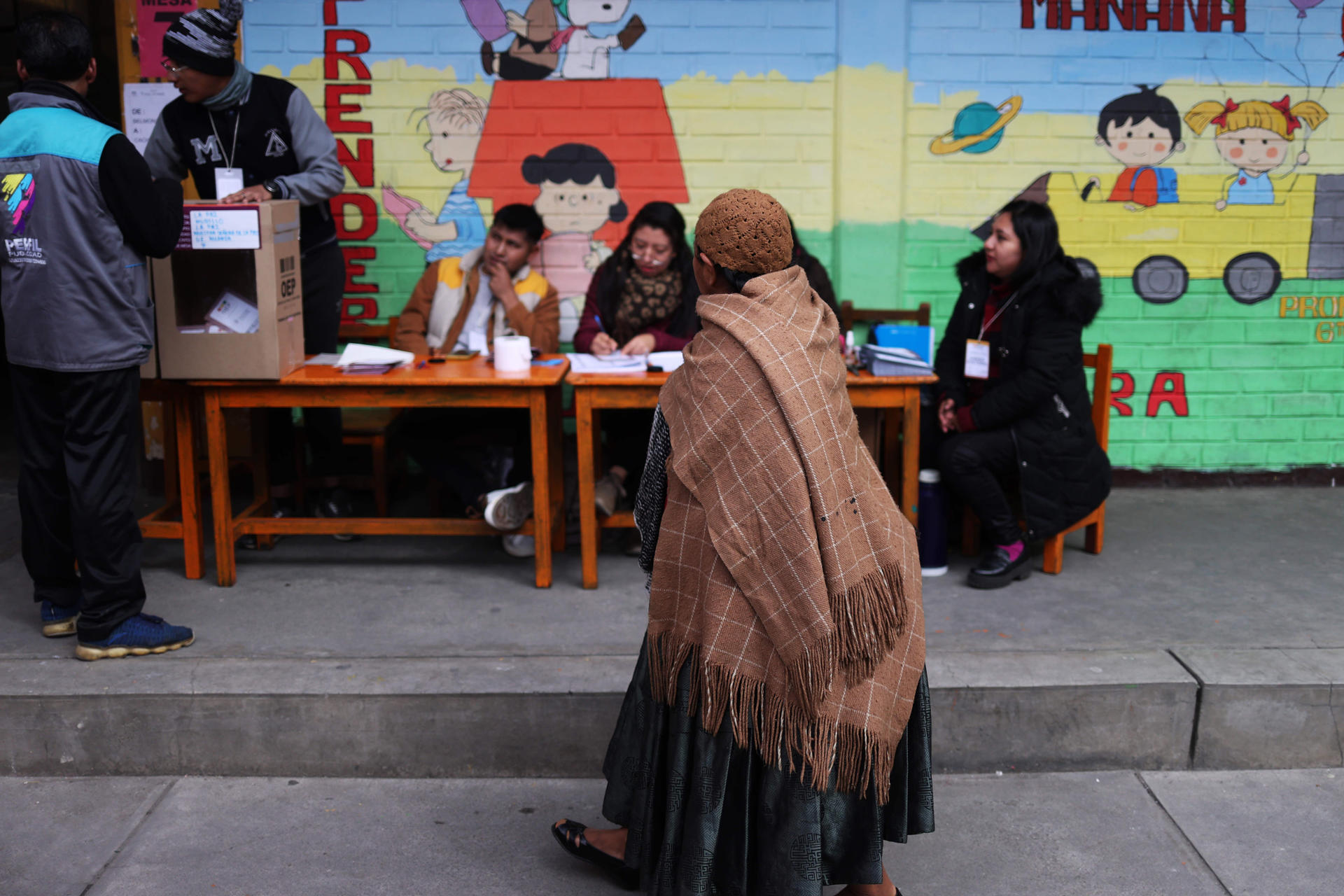 Una mujer aimara observa un puesto de votación durante las elecciones judiciales este domingo, en La Paz (Bolivia). EFE/ Luis Gandarillas
