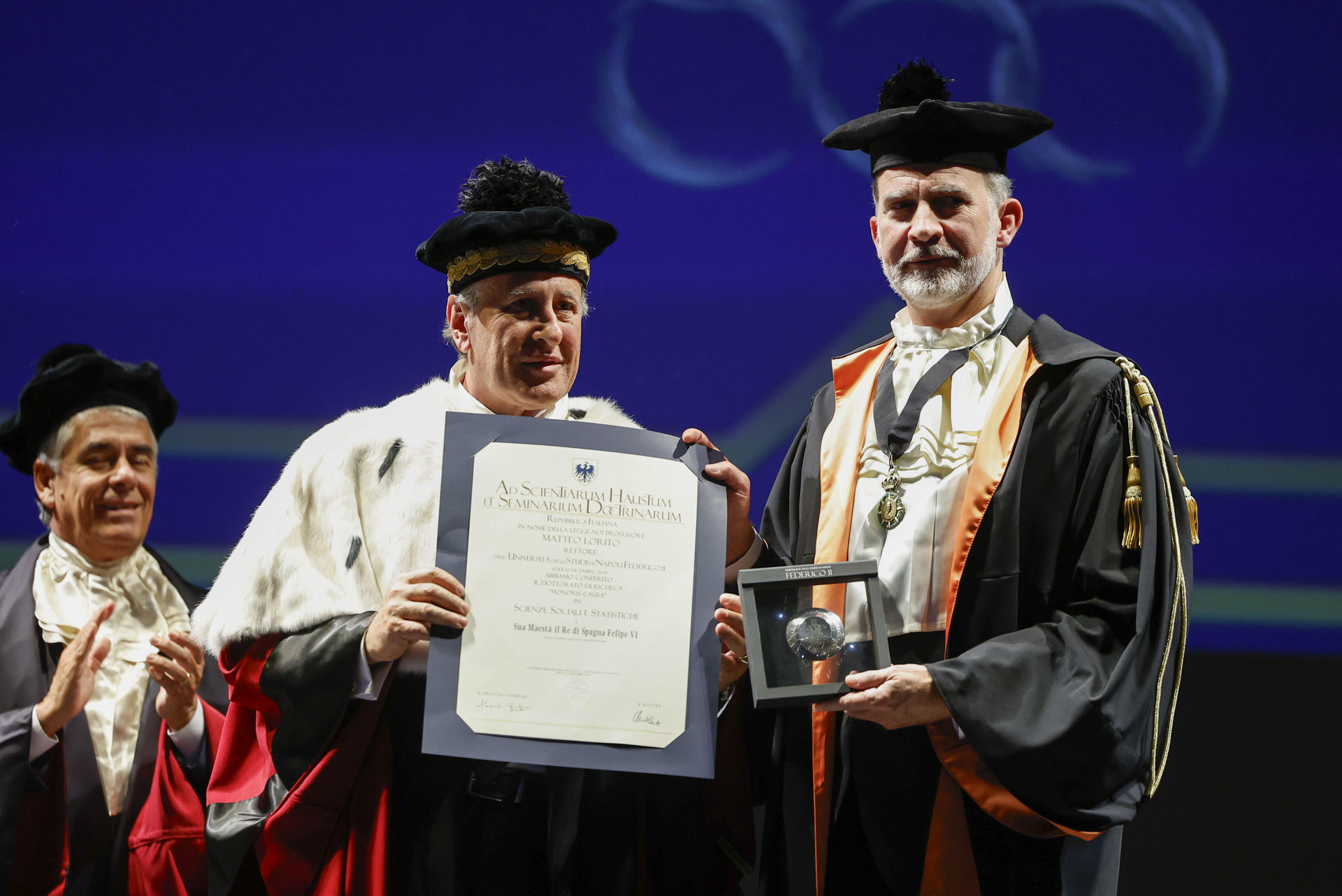 El rey Felipe VI (d) durante una ceremonia celebrada este jueves en el Teatro San Carlos de Roma (Italia), en la que ha sido investido como Doctor Honoris Causa por la Universidad Federico II de Nápoles, coincidiendo con el VIII centenario de su fundación, en el ámbito de su viaje oficial que finaliza hoy. EFE/ Chema Moya
