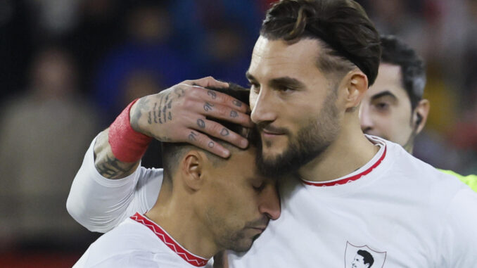 Los jugadores del Sevilla, Jesús Navas (i) y el serbio Nemanja Gudelj, durante el homenaje que ha recibido el centrocampista sevillista antes del inicio del encuentro correspondiente a la jornada 17 de Laliga EA Sports que disputan Sevilla y Celta en el estadio Sanchez Pizjuan de Sevilla. EFE/José Manuel Vidal.
