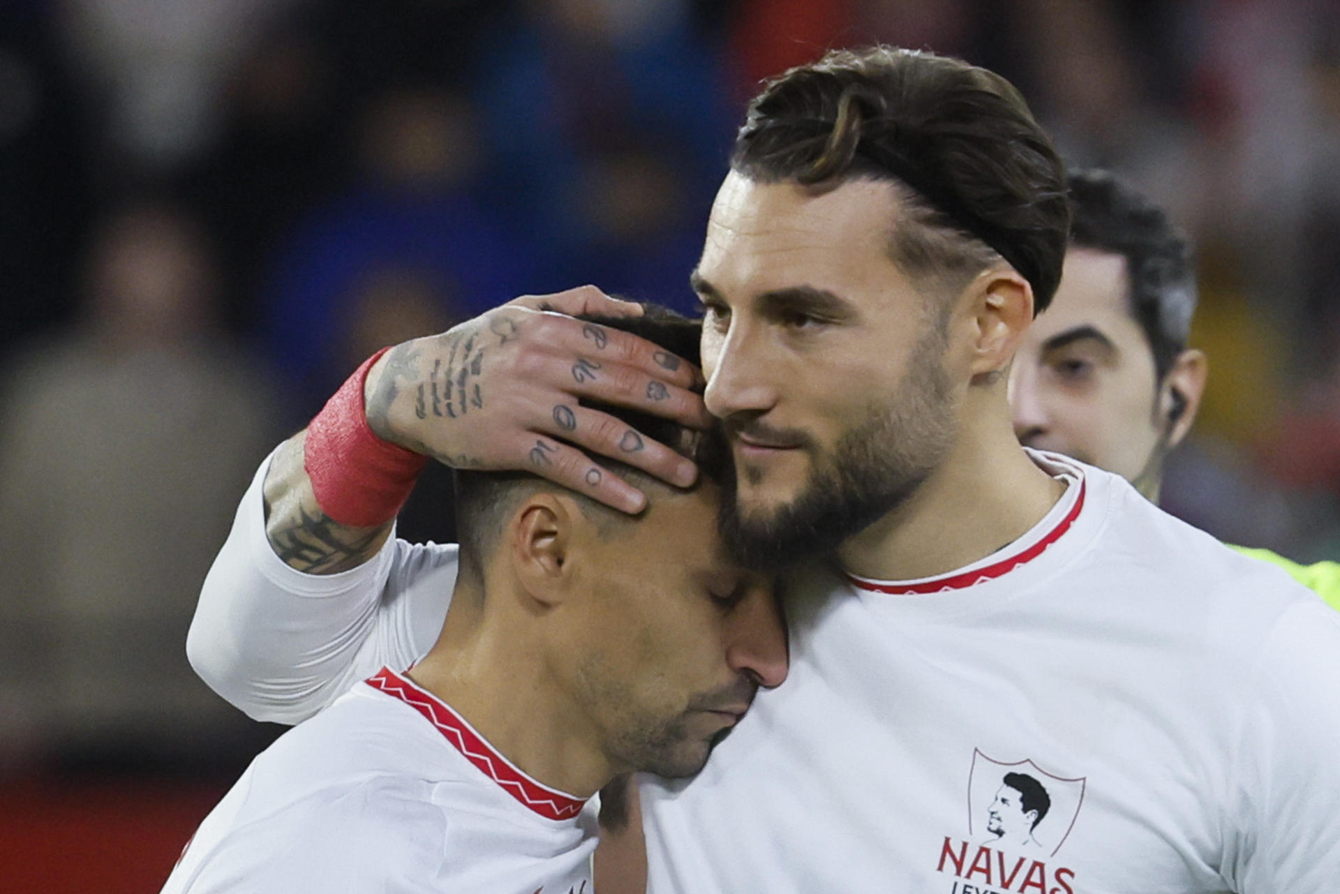 Los jugadores del Sevilla, Jesús Navas (i) y el serbio Nemanja Gudelj, durante el homenaje que ha recibido el centrocampista sevillista antes del inicio del encuentro correspondiente a la jornada 17 de Laliga EA Sports que disputan Sevilla y Celta en el estadio Sanchez Pizjuan de Sevilla. EFE/José Manuel Vidal.
