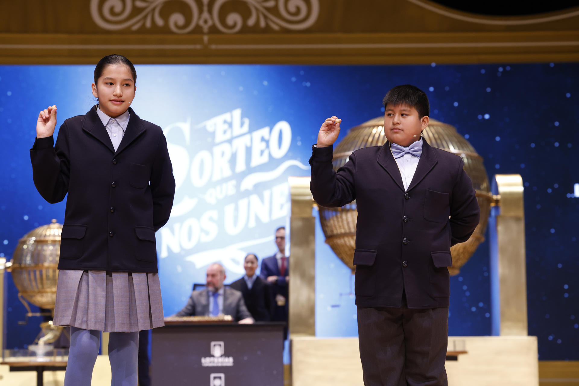 Los niños de la Residencia San Ildefonso de Madrid Piero Rai Chávez (d) y Alisce Ríos (i), muestran el número 48.020, segundo cuarto premio dotado con 200.000 euros a la serie, durante el Sorteo Extraordinario de Navidad que se celebra este domingo en el Teatro Real, en Madrid. EFE/Javier Lizón
