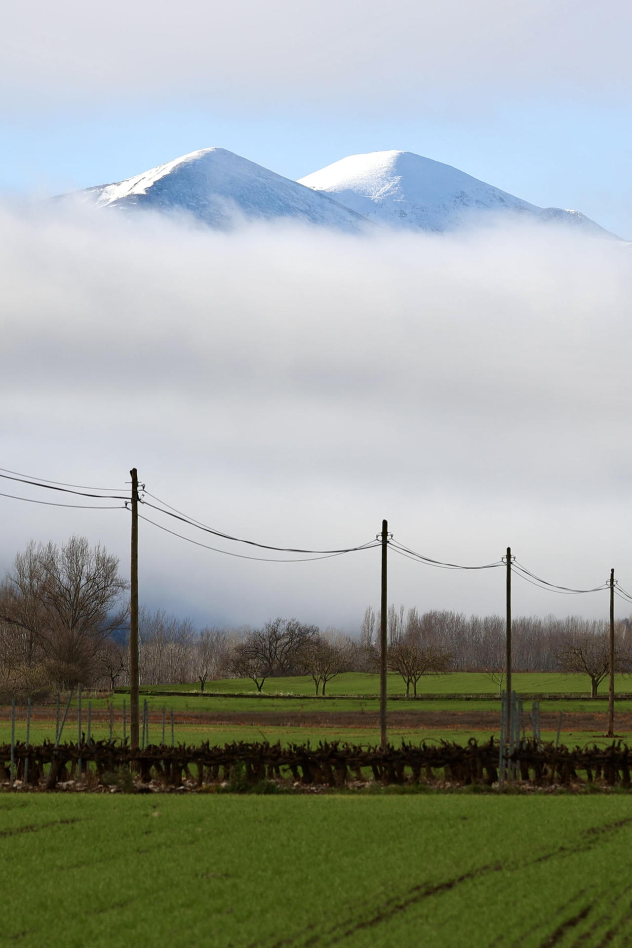 La niebla cubre este miércoles el Valle de San Millán de la Cogolla dejando al descubierto el Pico de San Lorenzo y Cabeza Parda, cubiertos por la nieve. Seis comunidades autónomas se encuentran hoy, día de Navidad, en alerta amarilla por niebla o fenómenos costeros, en el caso de Cataluña por ambos, según la Agencia Estatal de Meteorología (Aemet) en su página web. EFE/Raquel Manzanares
