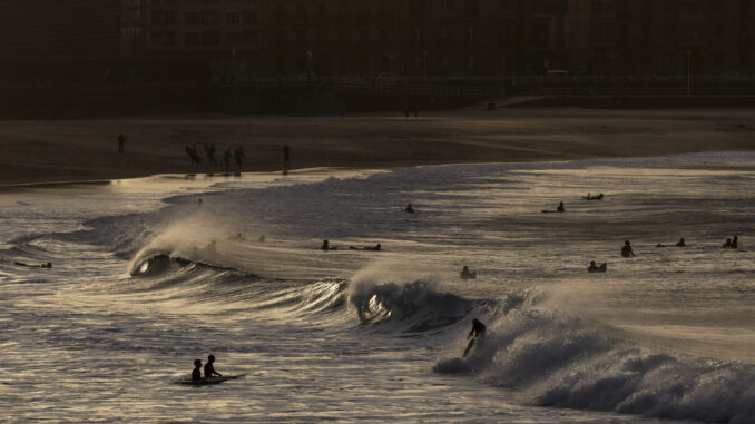 Surfistas disfrutan del oleaje en la playa de la Zurriola de San Sebastián. EFE/Juan Herrero
