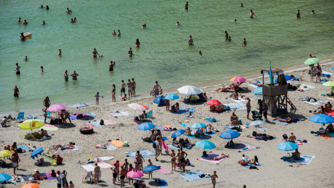 Los bañistas intentan paliar una ola de calor en la playa de Cala en Porter, Menorca, en una imagen de archivo. EFE/ David Arquimbau Sintes
