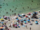 Los bañistas intentan paliar una ola de calor en la playa de Cala en Porter, Menorca, en una imagen de archivo. EFE/ David Arquimbau Sintes