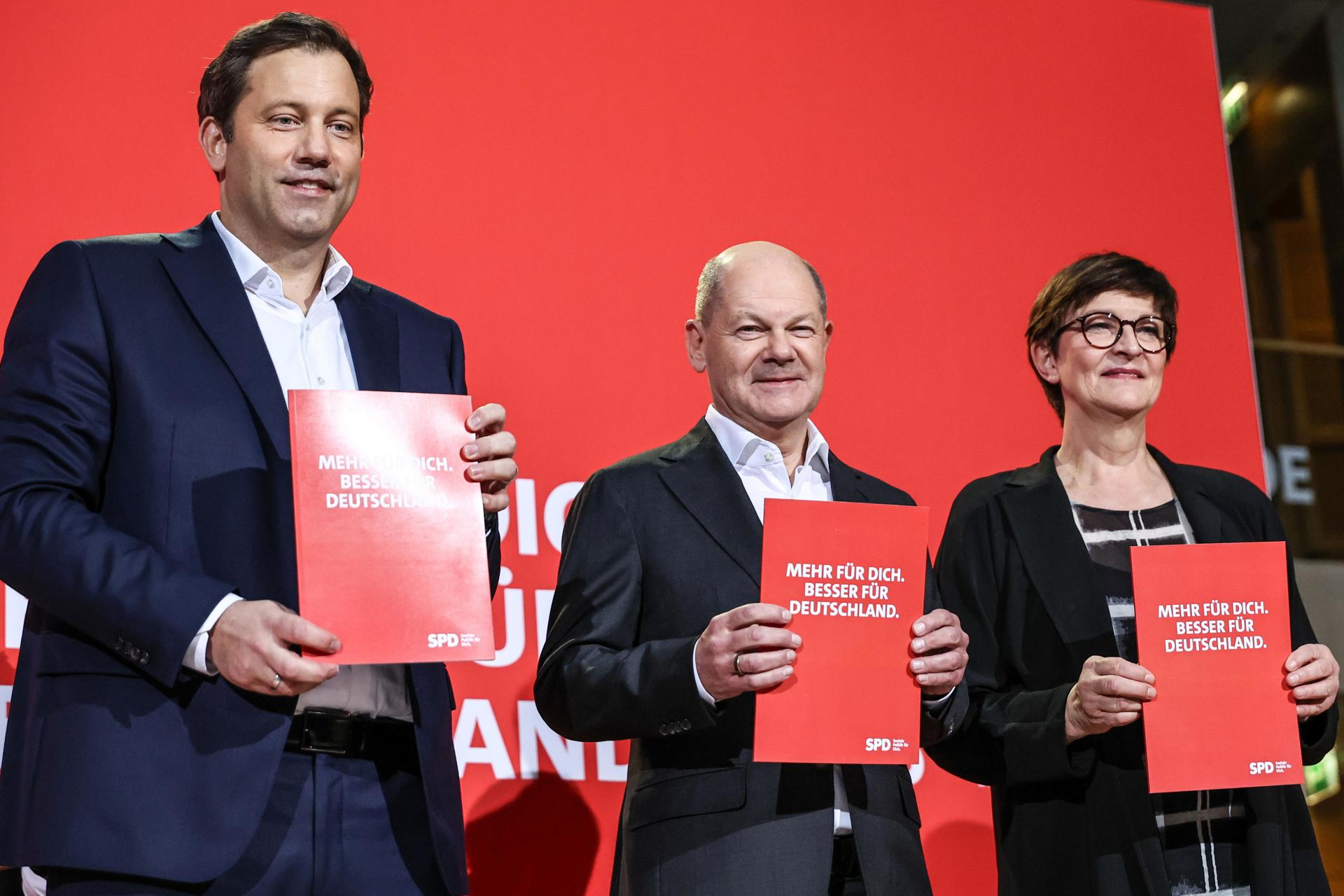 El canciller alemán Olaf Scholz (C) del Partido Socialdemócrata (SPD) se encuentra en el podio junto a los co-líderes del SPD, Saskia Esken (D) y Lars Klingbeil, durante el evento de presentación de campaña del SPD para las elecciones federales de 2025 en Berlín, Alemania, 17 de diciembre de 2024. (Elections, Germany) EFE/EPA/FILIP SINGER
