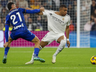 El delantero francés del Real Madrid Kylian Mbappé (d) pelea un balón con el defensa del Getafe Juan Iglesias en el partido de LaLiga entre el Real Madrid y el Getafe, este domingo en el estadio Santiago Bernabéu. EFE/ Sergio Pérez