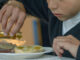 Un niño vierte aceite de oliva en el pan del desayuno en una imagen de archivo. EFE/José Manuel Pedrosa.