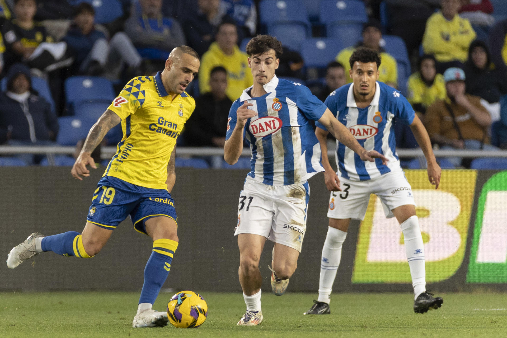 El delantero de la Unión Deportiva Las Palmas Sandro Ramírez (i) lucha con Antoniu Roca (c), del Espanyol, durante el partido de la jornada 18 de LaLiga EA Sports que UD Las Palmas y RCD Espanyol disputaron en el Estadio de Gran Canaria en Las Palmas de Gran Canaria. EFE/ Quique Curbelo
