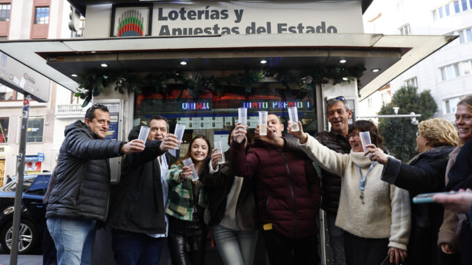 Celebraciones junto al quiosco de la calle Gran Vía de Madrid que ha vendido el número 45.225, el quinto de los ocho quintos premios del sorteo de la lotería de Navidad, dotado con 60.000 euros a la serie y con 6.000 euros cada décimo, este domingo. EFE/Rodrigo Jiménez
