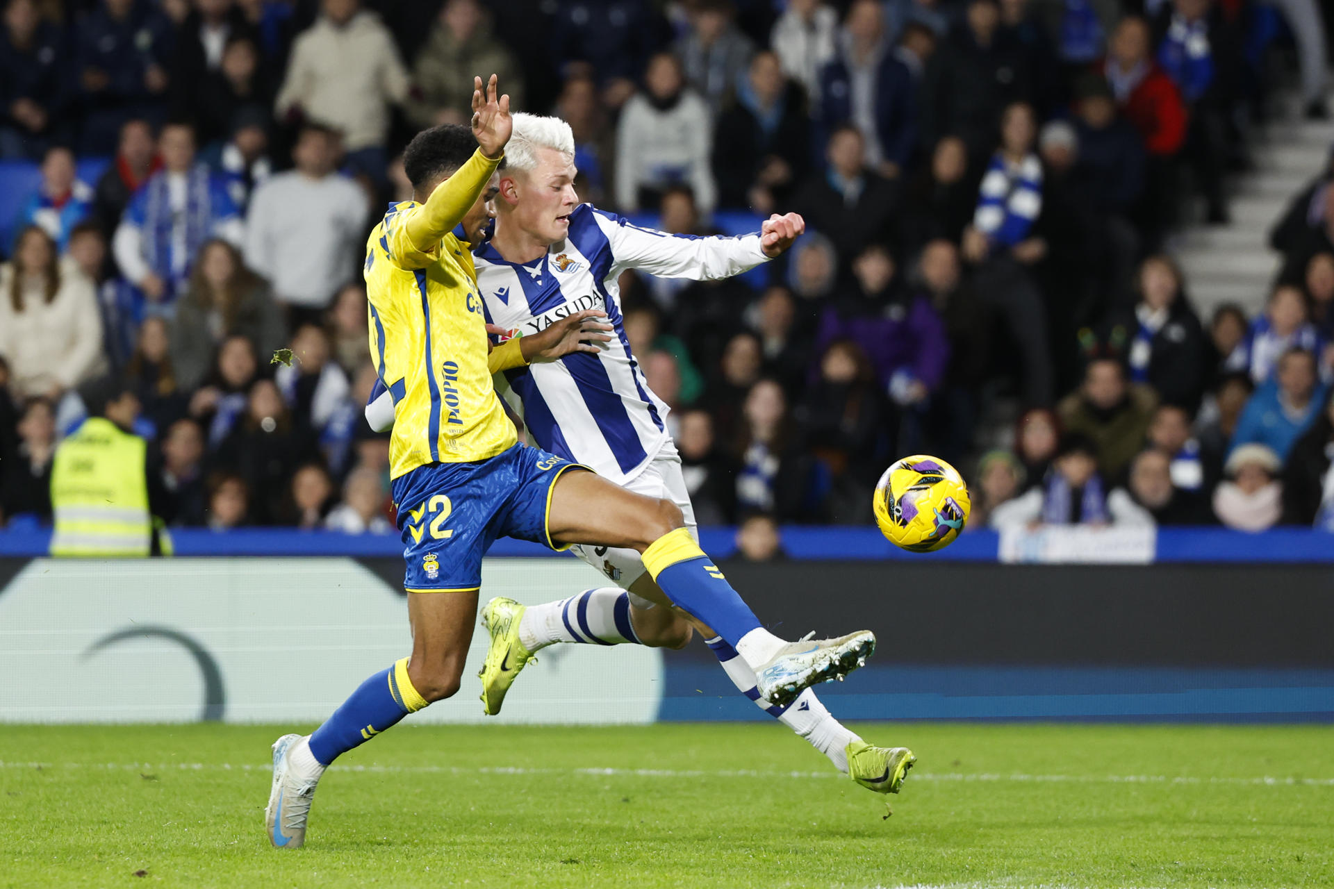 El delantero islandés de la Real Sociedad Orri Steinn Óskarsson (d) lucha con Marvin Olawale Akinlabi Park, de Las Palmas, durante el partido de la jornada 17 de LaLiga que Real Sociedad y UD Las Palmas disputaron en el Reale Arena. EFE/Javier Etxezarreta
