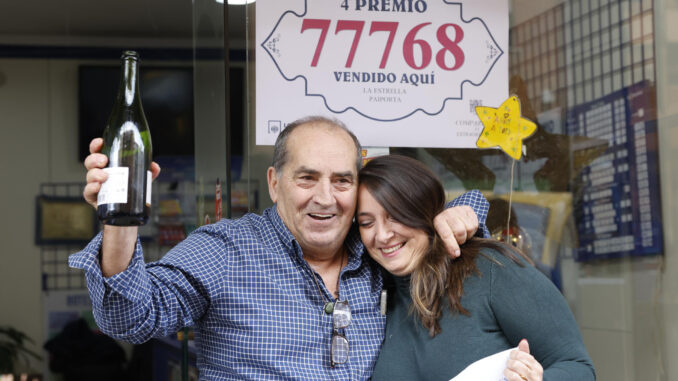 La lotera María del Carmen Rodríguez y su padre, Rafael Rodríguez, celebran a las puertas de la administración de lotería La Estrella, en Paiporta (Valencia), cerca del barranco del Poio, haber vendido parte de un cuarto (el 77.768) y de un quinto premio (el 37.876) del Sorteo Extraordinario de Navidad, este domingo. EFE/Ana Escobar
