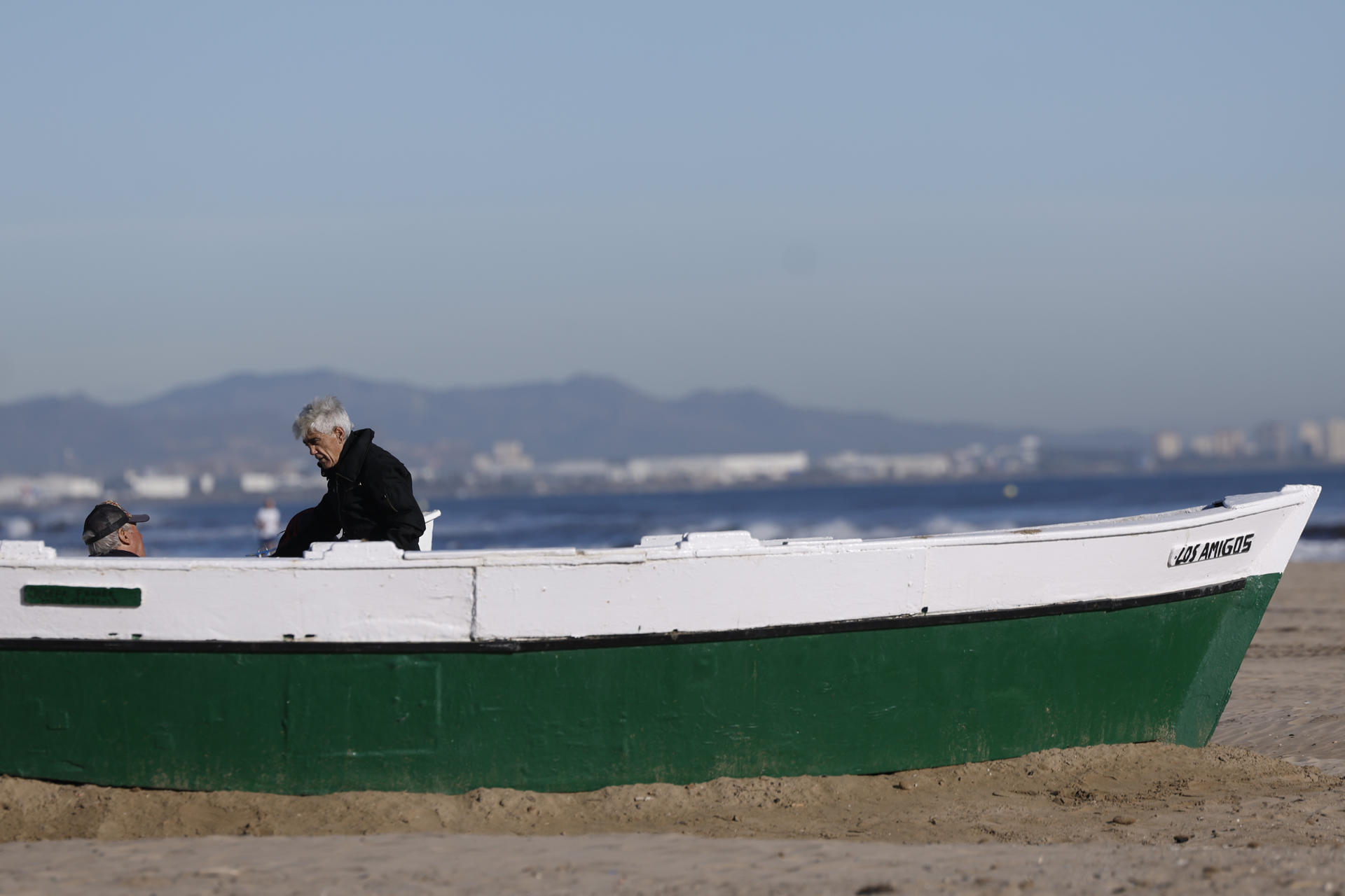 Dos personas disfrutan de una jornada soleada en la playa de la Malvarrosa, este martes, día de nochebuena. EFE/Kai Forsterling
