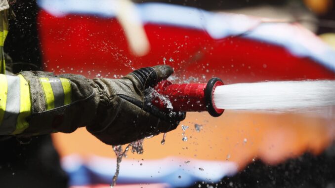 Imagen de archivo de la mano de un bombero que sostiene una manguera para sofocar un incendio. EFE/ Carlos Ortega
