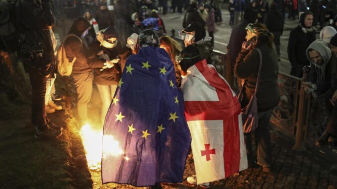 Partidarios de la oposición georgiana encienden fuego durante una manifestación frente al edificio del Parlamento en Tbilisi, Georgia, el 4 de diciembre de 2024. EFE/EPA/David Mdzinarashvili
