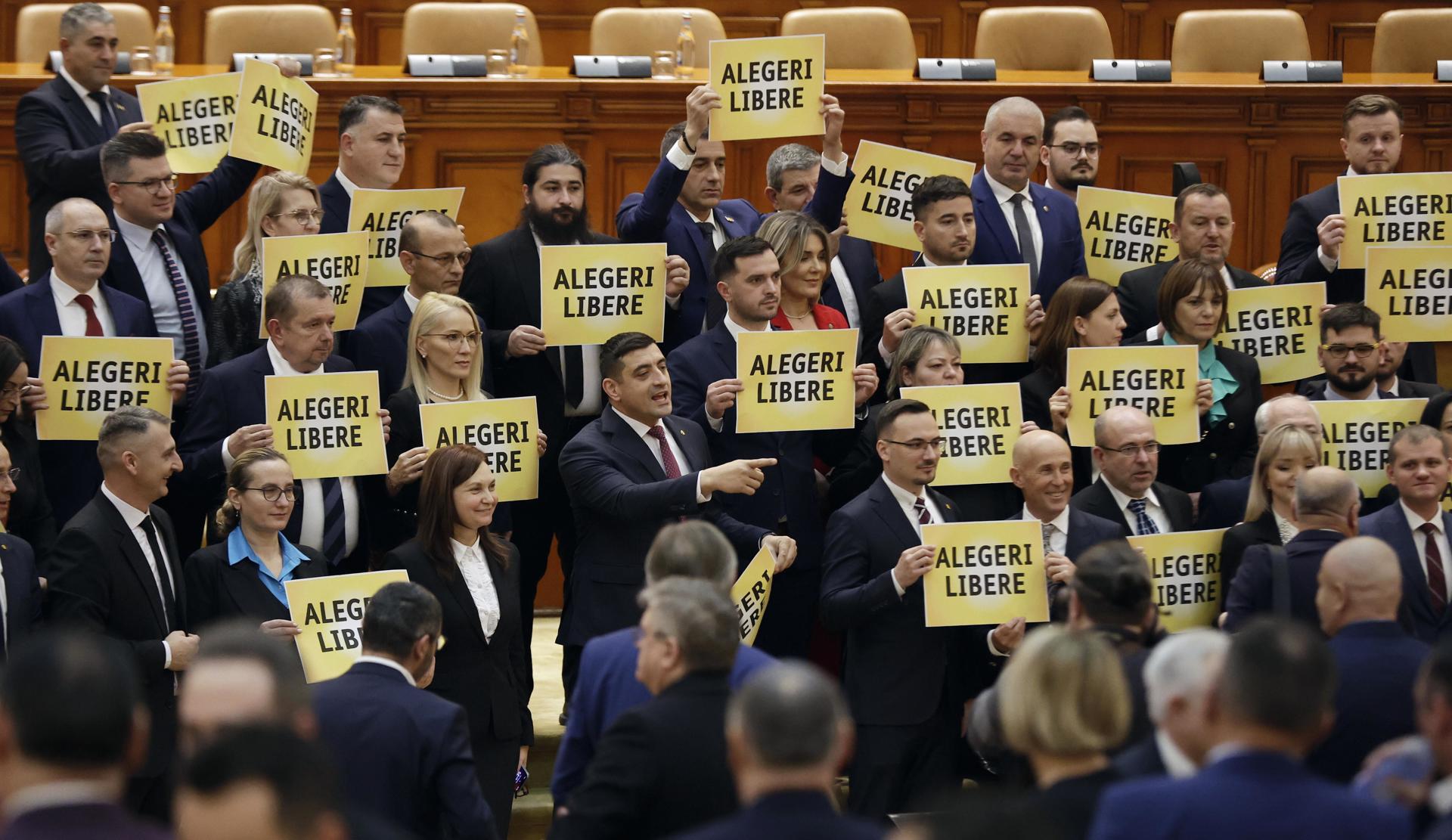 George Simion (C), líder del partido ultra-nacionalista AUR (Alianza por la Unión de Rumanos), gesticula durante una protesta celebrada al final de la primera sesión plenaria de la nueva asamblea del Parlamento en Bucarest, Rumanía, 20 de diciembre de 2024. Los carteles que sostienen los miembros del partido AUR dicen 'ELECCIONES LIBRES', haciendo referencia a la decisión del Tribunal Constitucional de anular los resultados de las elecciones presidenciales. El presidente rumano Iohannis convocó una sesión conjunta de las dos cámaras del nuevo parlamento, que fue elegido en las elecciones del 01 de diciembre. (Elecciones, Protestas, Rumanía, Bucarest) EFE/EPA/ROBERT GHEMENT
