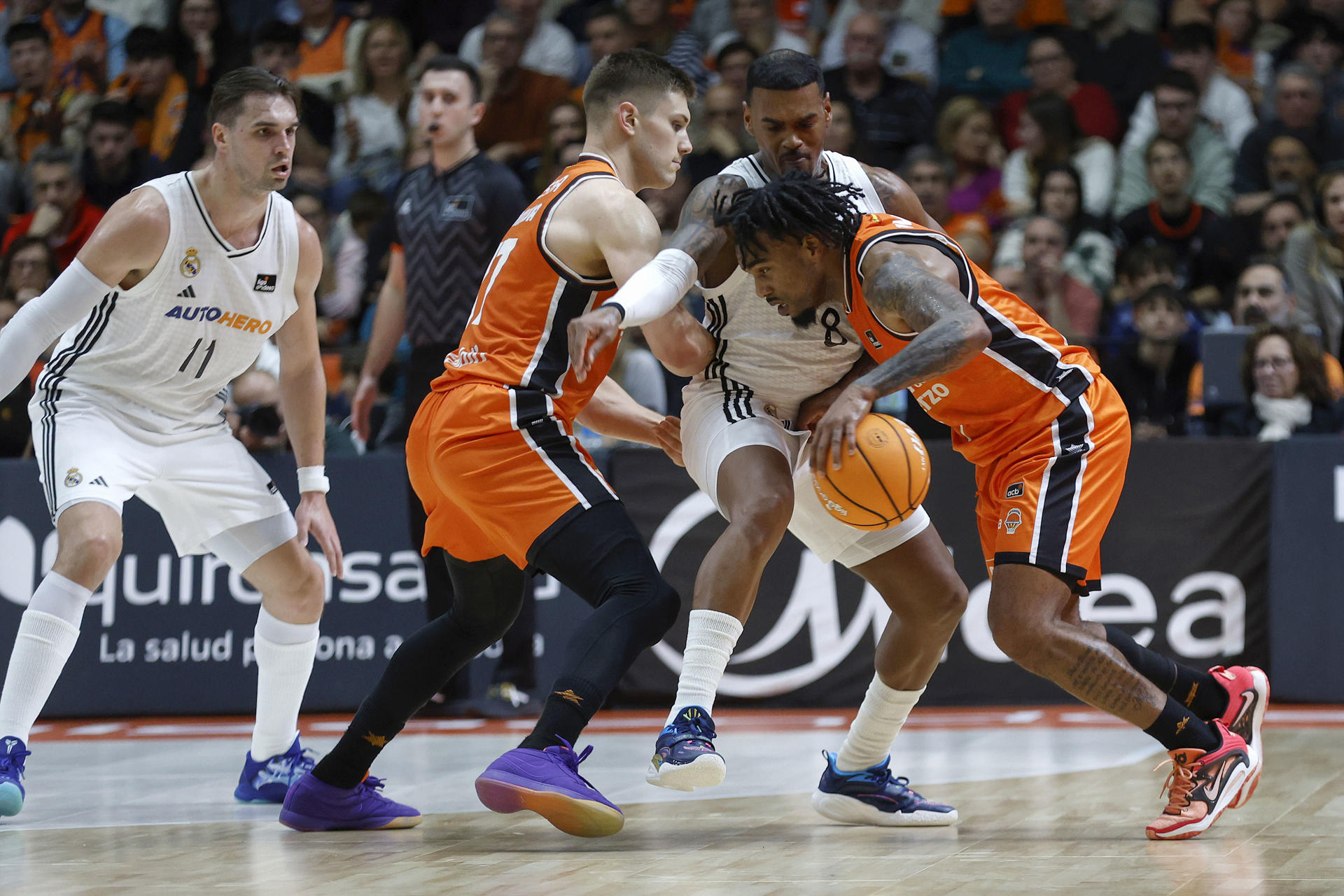 El escolta canadiense del Real Madrid Xavier Rathan Mayes (2d) defiende al base estadounidense del Valencia Basket Chris Jones (d) en el partido de Liga Endesa de baloncesto que se disputó en la Fonteta. EFE/Miguel Ángel Polo.
