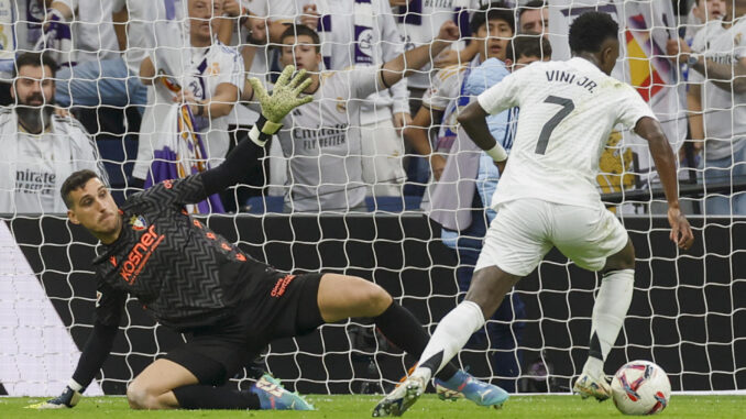 El delantero brasileño del Real Madrid Vinicius Junior (d) en el momento de anotar uno de los tres goles que marcó a Osasuna, el 9 de noviembre, en el estadio Santiago Bernabéu. EFE/Javier Lizón
