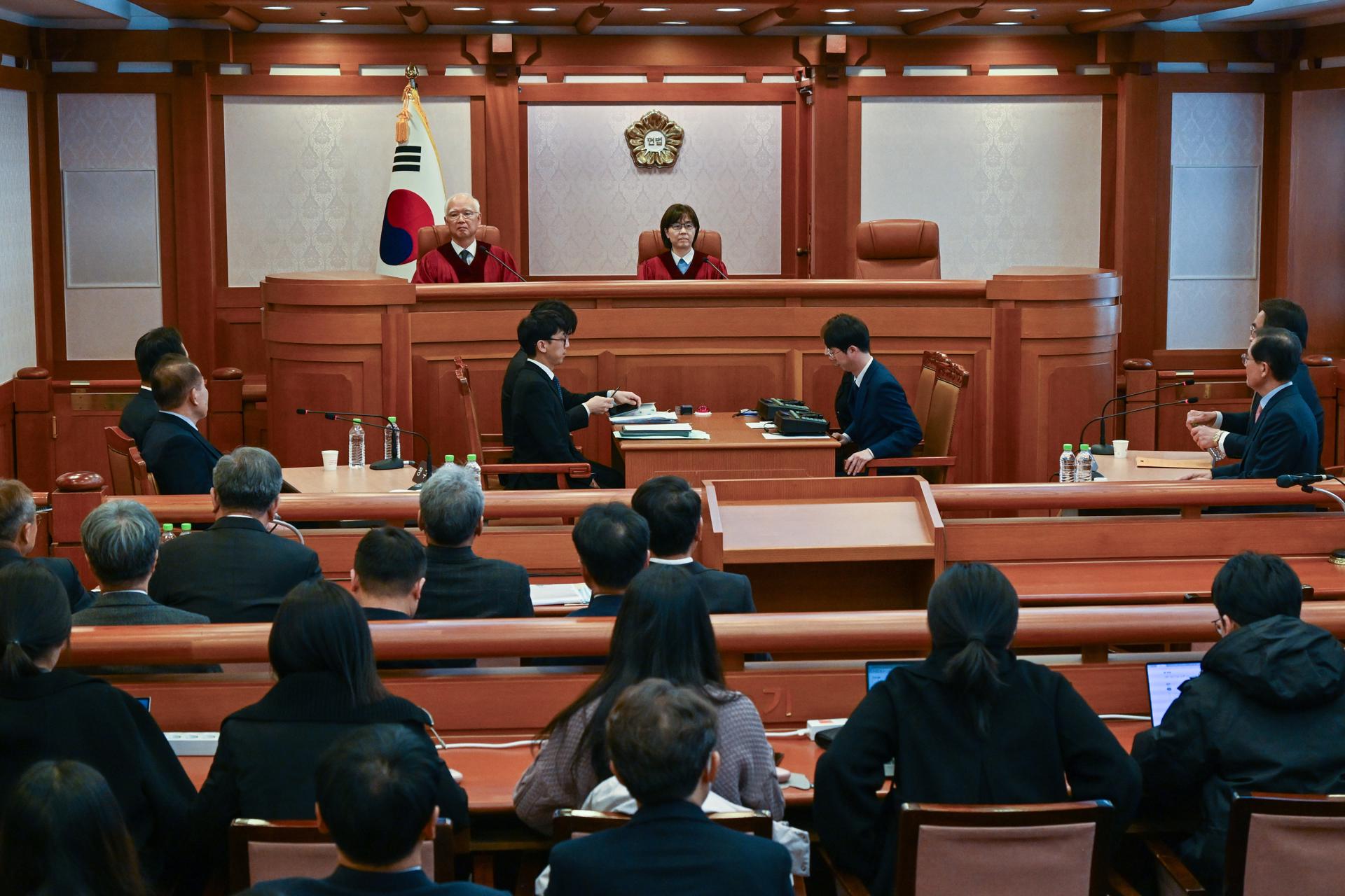 Los jueces del Tribunal Constitucional de Corea del Sur Lee Mi-son (c) y Cheong Hyung-sik (i), se sientan durante la audiencia preliminar del juicio para determinar si el presidente Yoon Suk-yeol debe ser definitivamente destituido o no por declarar la ley marcial a principio de mes, en Seúl, el 27 de diciembre de 2024. EFE/EPA/Song Kyung-Seok/POOL
