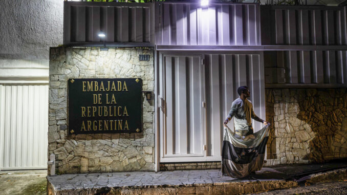 Fotografía de archivo de una persona que sostiene la bandera de Venezuela en color negro frente a la embajada de Argentina este lunes, en Caracas (Venezuela). EFE/ Henry Chirinos
