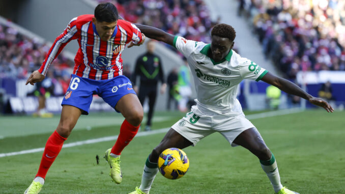 El centrocampista del Getafe Coba da Costa (d) lucha un balón con el defensa argentino del Atlético de Madrid Nahuel Molina (i) durante el partido de Liga que disputaron Atlético de Madrid y Getafe este domingo en el estadio Riyadh Air Metropolitano. EFE/Juanjo Martín
