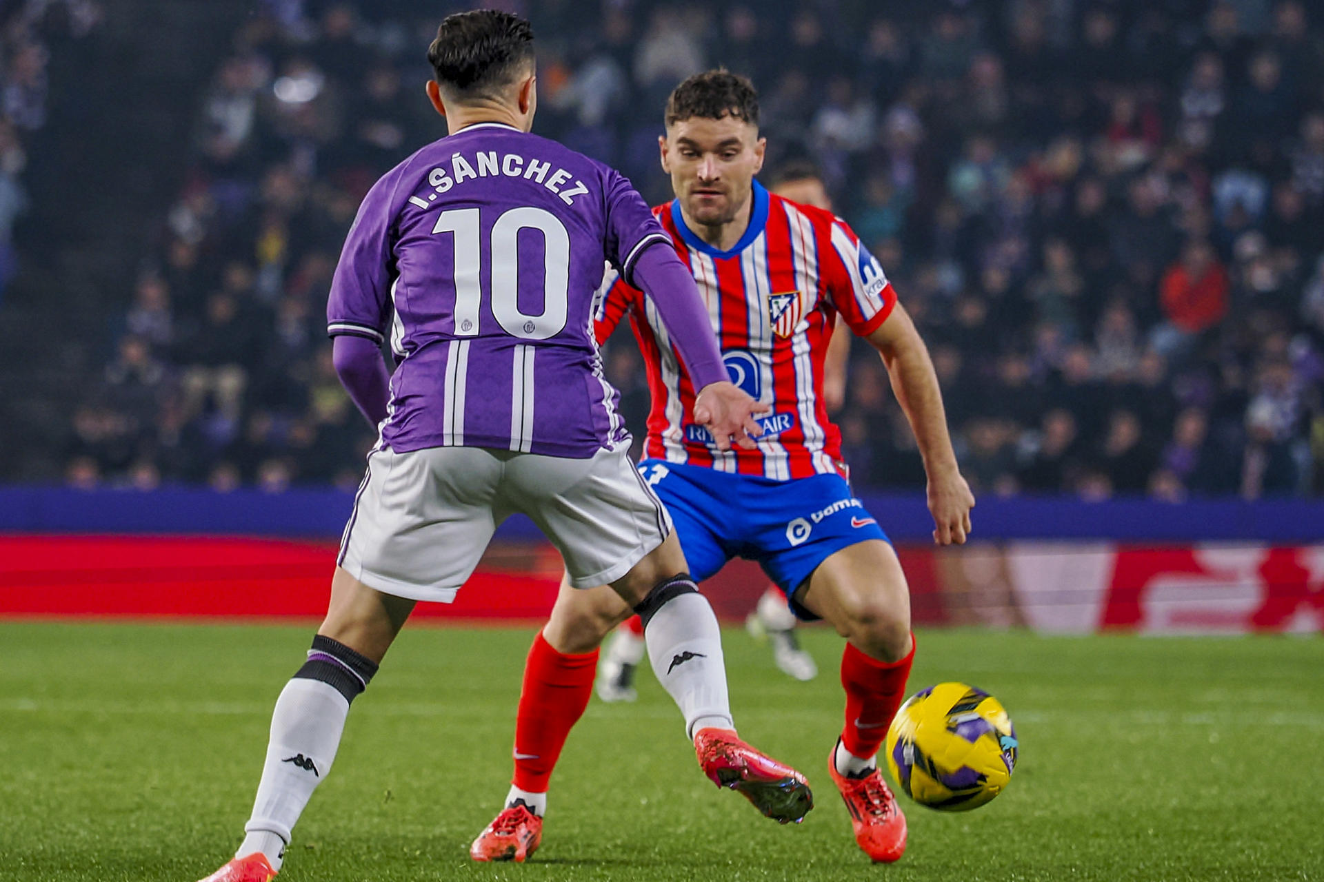 El defensa del Atlético de Madrid Javi Galán (d) y el centrocampista del Valladolid Iván Sánchez durante el partido de LaLiga entre el Real Valladolid y el Atlético de Madrid, este sábado en el estadio José Zorrilla. EFE/R. GARCIA.
