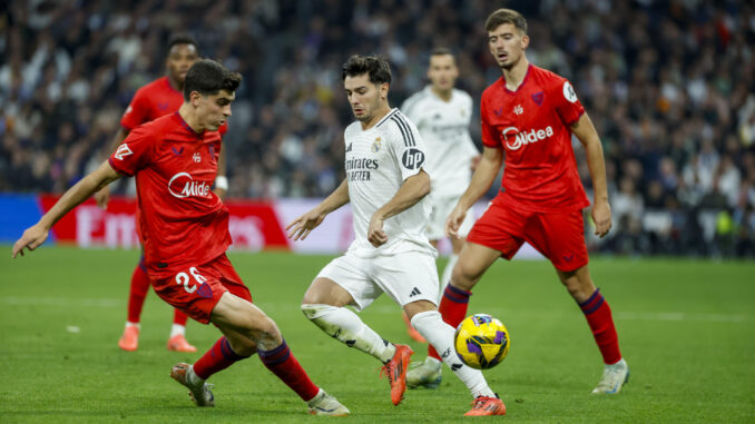 El centrocampista del Real Madrid Brahim Díaz (c) y el delantero del Sevilla Juanlu Sánchez (i)  durante el partido de LaLiga entre el Real Madrid y el Sevilla, este domingo en el estadio Santiago Bernabéu. EFE/ JuanJo Martín
