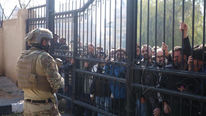 Un combatiente rebelde asegura el área mientras la gente espera para registrarse en una sucursal del centro para el proceso de registro y reconciliación en el distrito de Mezzeh, Damasco, Siria, el 21 de diciembre de 2024. El Departamento de Operaciones Militares abrió el primer centro para el proceso de registro y reconciliación de ex miembros del régimen sirio en el barrio de Mezzeh en Damasco.EFE/EPA/Mohammed Al Rifai
