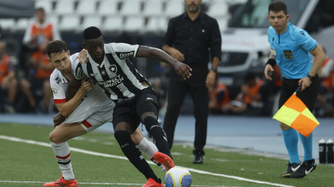 Patryck, de Sao Paulo, marca a Luiz Henrique (d), de Botafogo en el estadio Olímpico Nilton Santos, en Río de Janeiro. EFE/ Antonio Lacerda
