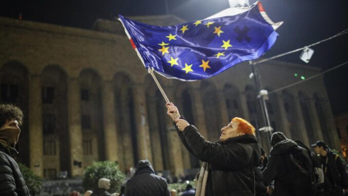 Un partidario de la oposición georgiana ondea la bandera de la Unión Europea durante una protesta frente al edificio del Parlamento en Tiflis, el 3 de diciembre de 2024. EFE/EPA/DAVID MDZINARISHVILI
