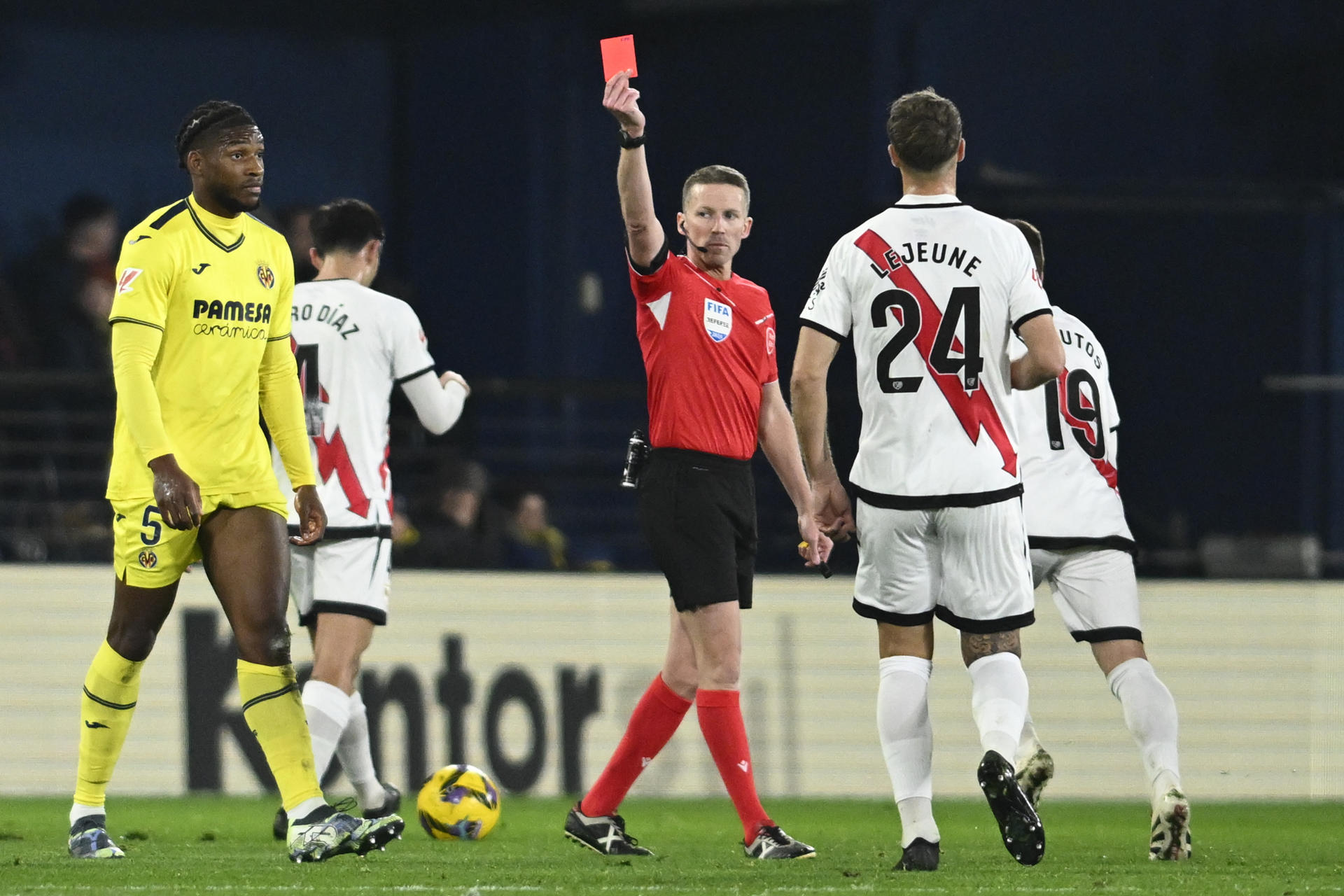 El árbitro Hernández Hernández (2-d) muestra la tarjeta roja a Willy Kambwala (i), del Villarreal, durante el partido de LaLiga que Villarreal CF y Rayo Vallecano disputan este miércoles en el estadio de La Cerámica. EFE/Andreu Esteban
