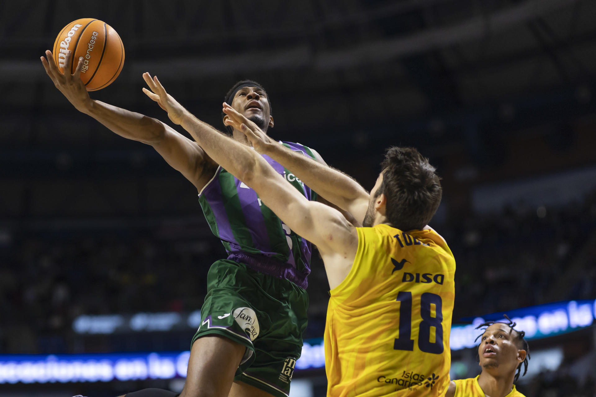 El escolta estadounidense del Unicaja, Kameron Taylor (i), entra a canasta ante la defensa del pívot estadounidense del Dreamland Gran Canaria, Mike Tobey, durante el partido de la jornada 11 de la Liga Endesa disputado en el Palacio de Deportes José María Martín Carpena. EFE/Carlos Díaz.
