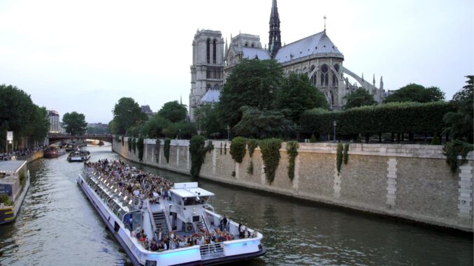 Un barco con turistas navegando por el Sena junto a la catedral de Notre Dame. EFE/Horacio Villalobos
