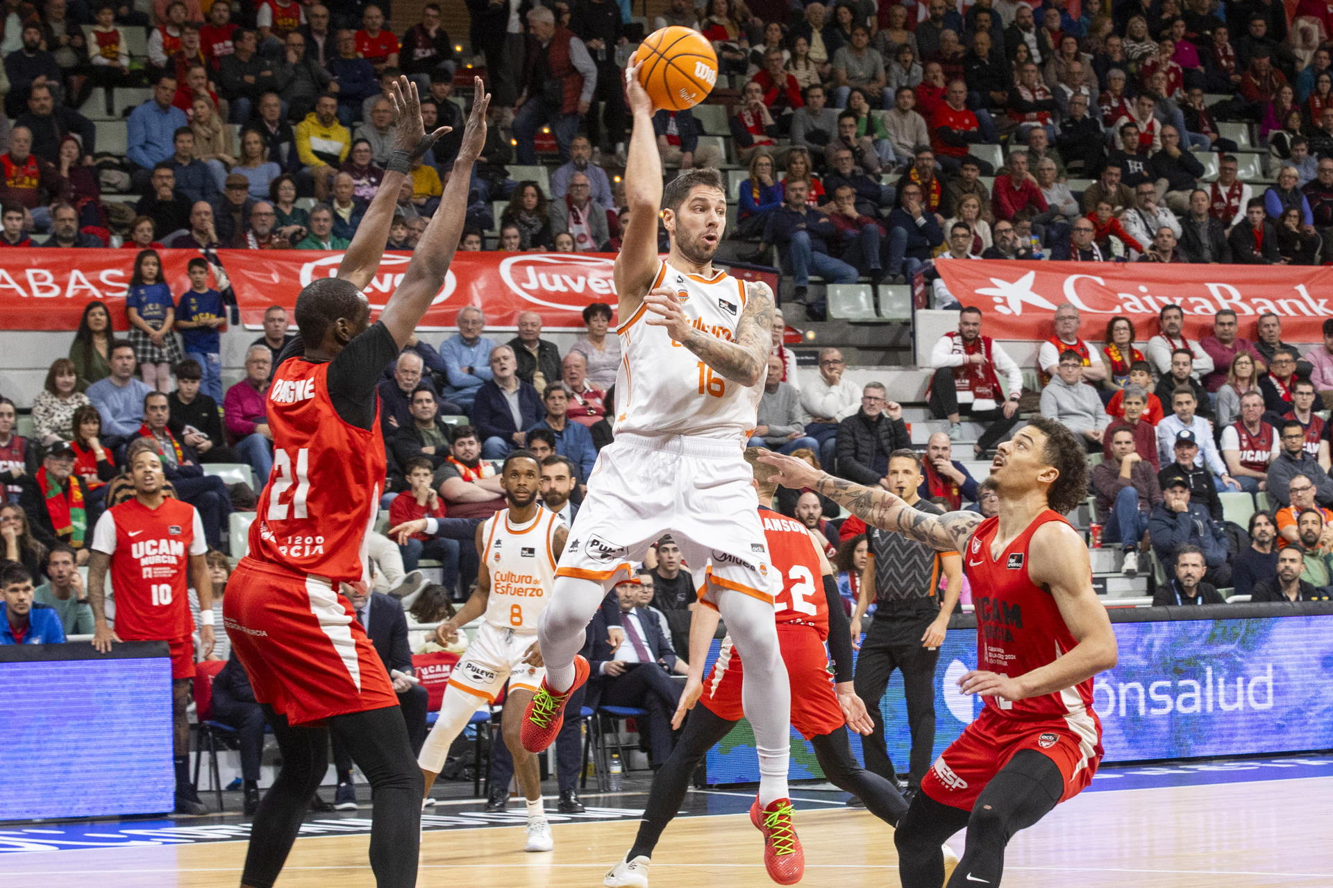 El base serbio de Valencia Basket Stefan Jovic (c) controla el balón ante la presión del pívot de UCAM Murcia Moussa Diagne (i), durante el partido de la décimo primera jornada de la liga Endesa jugado en el Palacio de los Deportes de Murcia.- EFE/Marcial Guillén
