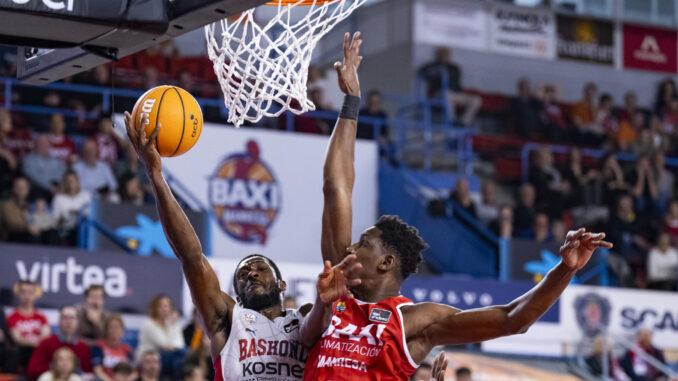 El base georgiano del Saski Baskoni Kamar Baldwin (i) entra a canasta ante el ala-pívot gambiano del Baxi Manresa Musa Sagnia (d) durante el encuentro de la jornada decimotercera de la Liga Endesa entre el Baxi Manresa y el Saski Baskonia, este domingo en el Pabellón Nou Congost de Manresa. EFE/Siu Wu
