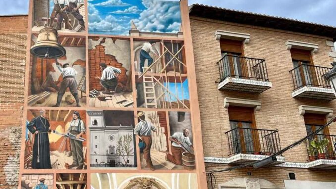 El mural de Demeseone en Fuenlabrada representa la construcción de la Iglesia de San Esteban, destacando el patrimonio local a través del arte urbano.