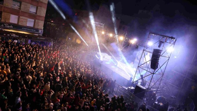 Vecinos de Móstoles disfrutando de las preuvas en la Plaza de España, con música y reparto gratuito de uvas.