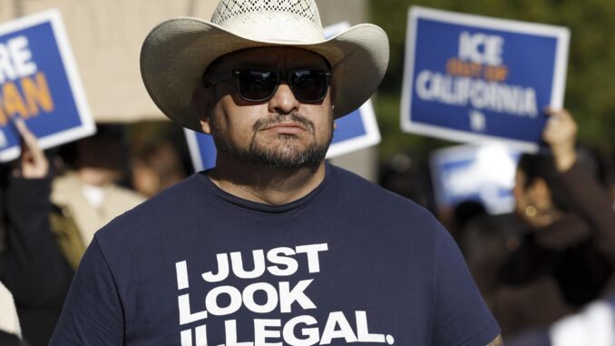 Fotografía de archivo de un hombre con una camiseta en la que se lee "Solo parezco ilegal", durante una manifestación en protesta contra las propuestas que está discutiendo la Administración entrante de Donald Trump para la deportación generalizada de inmigrantes, en el Capitolio del Estado en Sacramento, California, EE. UU., el 2 de diciembre de 2024. EFE/EPA/John G. Mabanglo
