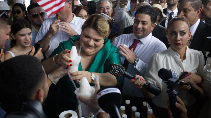 Fotografía de archivo del pasado 2 de enero de la gobernadora de Puerto Rico Jenniffer González (i) mientras recibe un limber (paleta helada) de coco luego de su investidura frente al Capitolio en San Juan (Puerto Rico). EFE/ Thais Llorca
