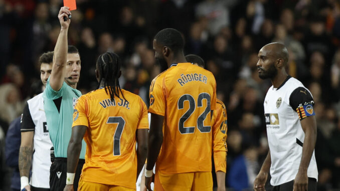 El colegiado Soto Grado muestra tarjeta roja al delantero brasileño del Real Madrid, Vinicius Junior (i), durante el encuentro correspondiente a la jornada 12 de Laliga EA Sports que disputaron el viernes Valencia y Real Madrid en el estadio de Mestalla, en Valencia. EFE / Biel Aliño.
