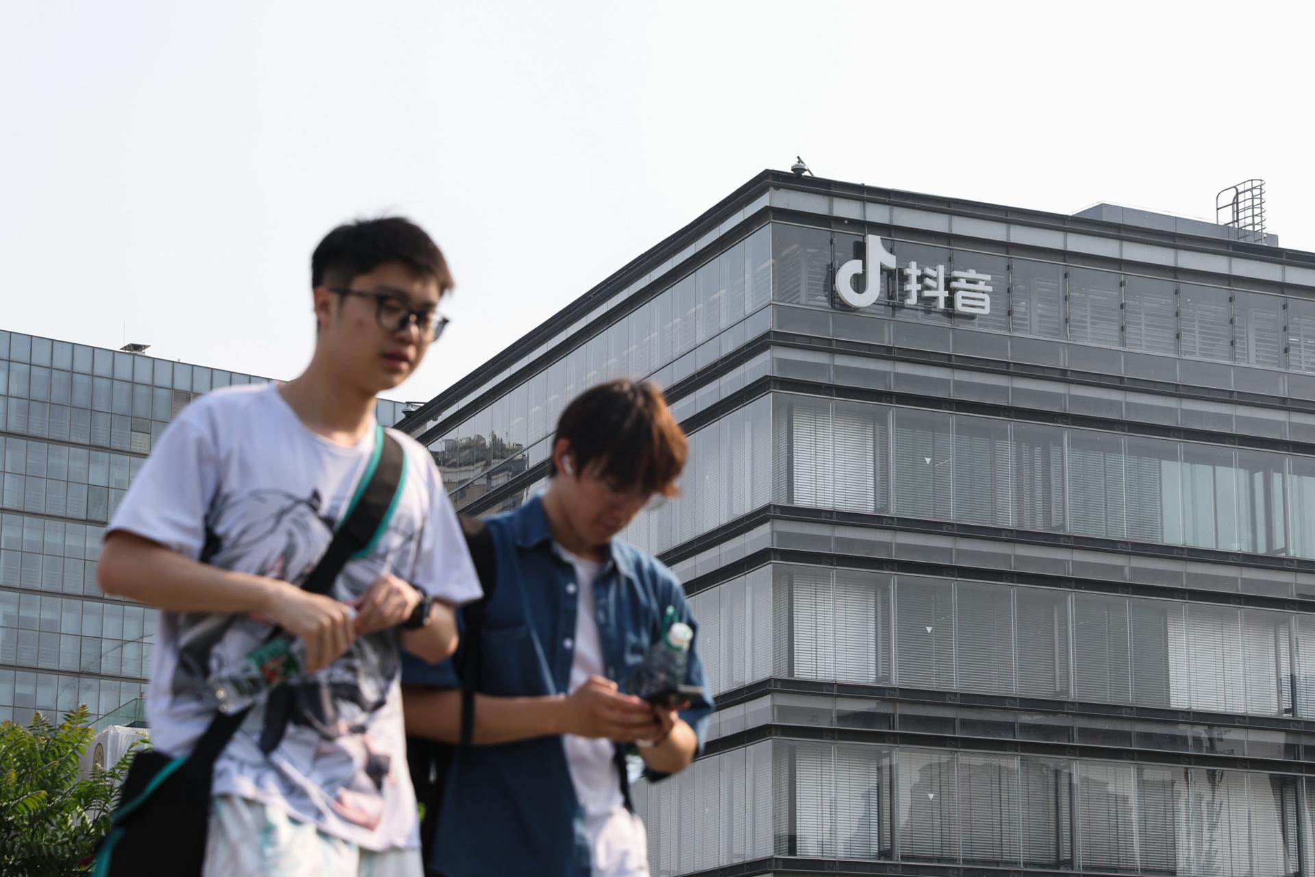 Fotografía de archivo en donde se ven dos jóvenes caminan frente a las oficinas de ByteDance, matriz de TikTok, en Pekín (China). EFE/ WU HAO
