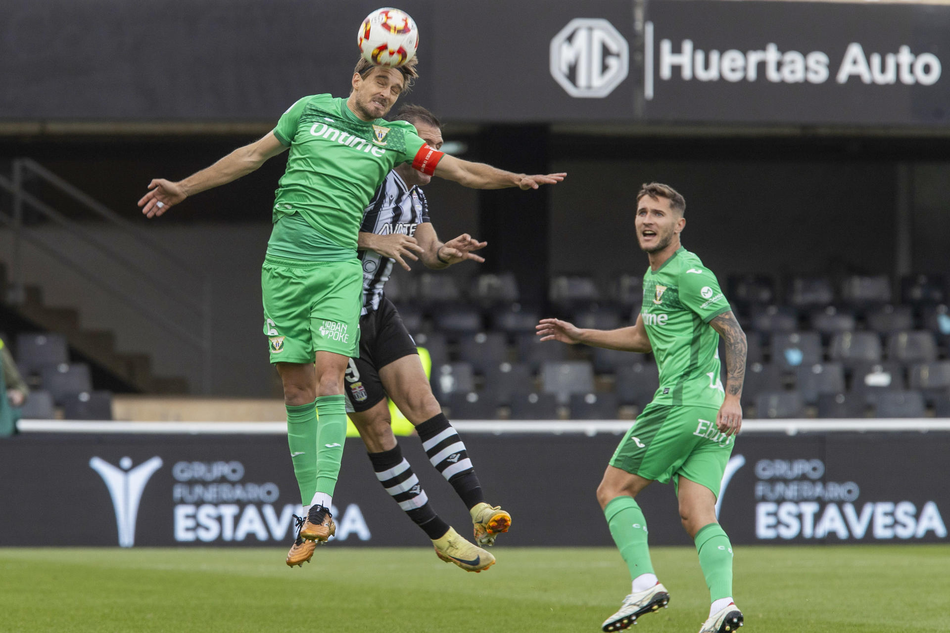 El jugador del C.D Leganés Sergio González (i) despeja de cabeza ante el jugador F.C. Cartagena Ortuño (c), durante el partido correspondiente a los dieciseisavos de final de la Copa del Rey, que están disputando este domingo en el estadio Cartagonova en Cartagena (Murcia). EFE/Marcial Guillén
