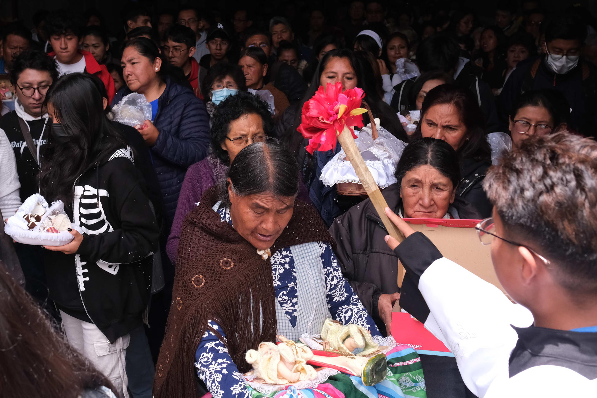 Fieles católicos reciben agua bendita durante la misa de Reyes este lunes, en La Paz (Bolivia). EFE/ Luis Gandarillas
