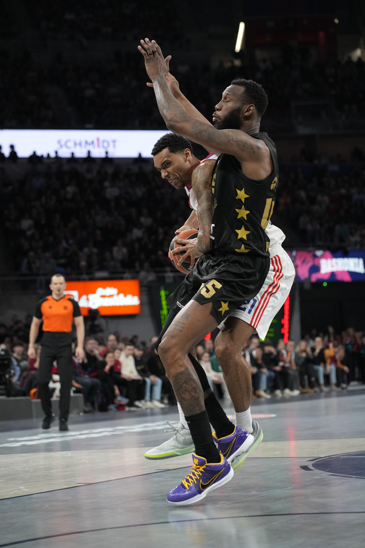 El pívot de Estrella Roja Joel Bolomboy (i) lucha con Donta Hall, del Baskonia, durante el partido de la jornada 19 de la EuroLiga que Baskonia y Estrella Roja disputan este jueves en el Fernando Buesa Arena, en Vitoria. EFE/Adrián Ruiz Hierro
