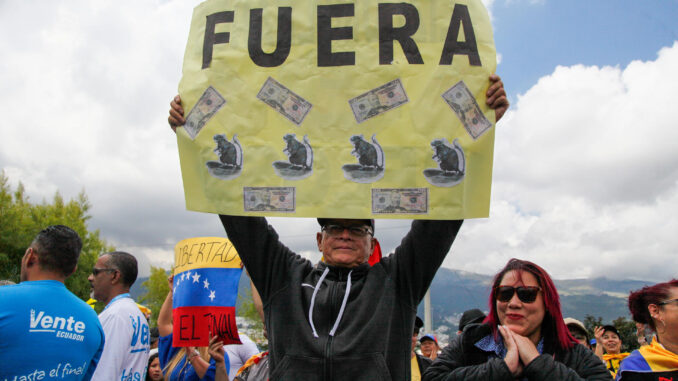 Un hombre de nacionalidad venezolana sostiene un cartel durante una manifestación este jueves, en Quito (Ecuador). La comunidad venezolana afincada en Quito (Ecuador). EFE/ José Jácome
