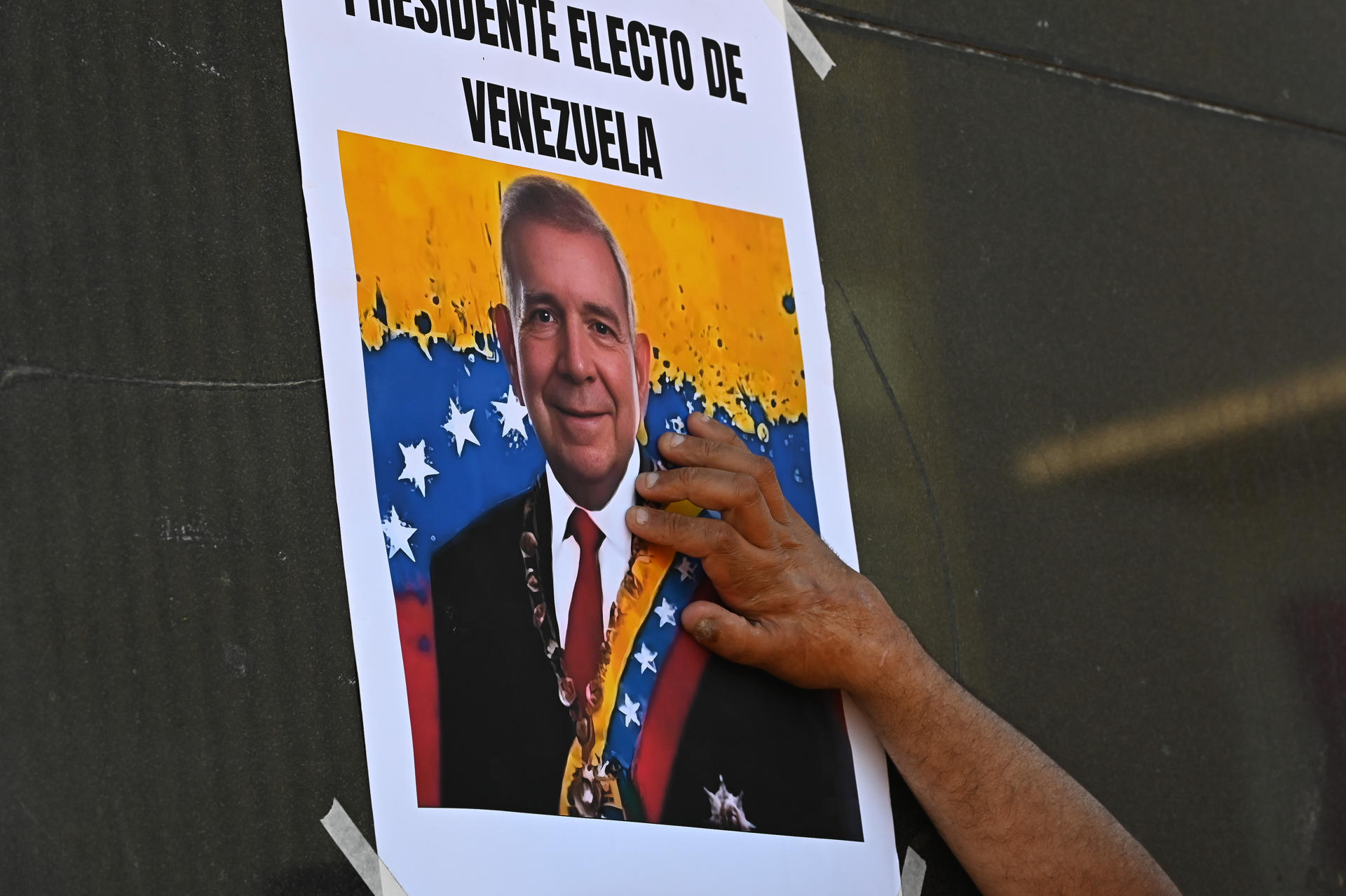 Una persona pega un cartel durante una concentración en la plaza Simón Bolívar este Jueves, en la ciudad de Montevideo (Uruguay). EFE/ Federico Gutiérrez
