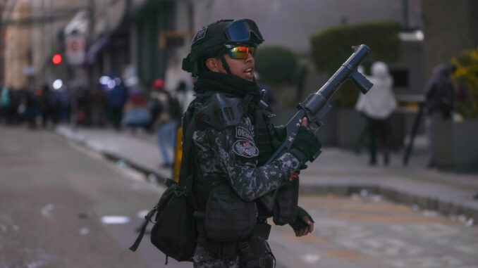 Un miembro de la policía boliviana de enfrenta con simpatizantes del expresidente Evo Morales (2006-2019) durante una marcha en contra de los procesos judiciales al exmandatario este lunes, en La Paz (Bolivia). EFE/ Luis Gandarillas
