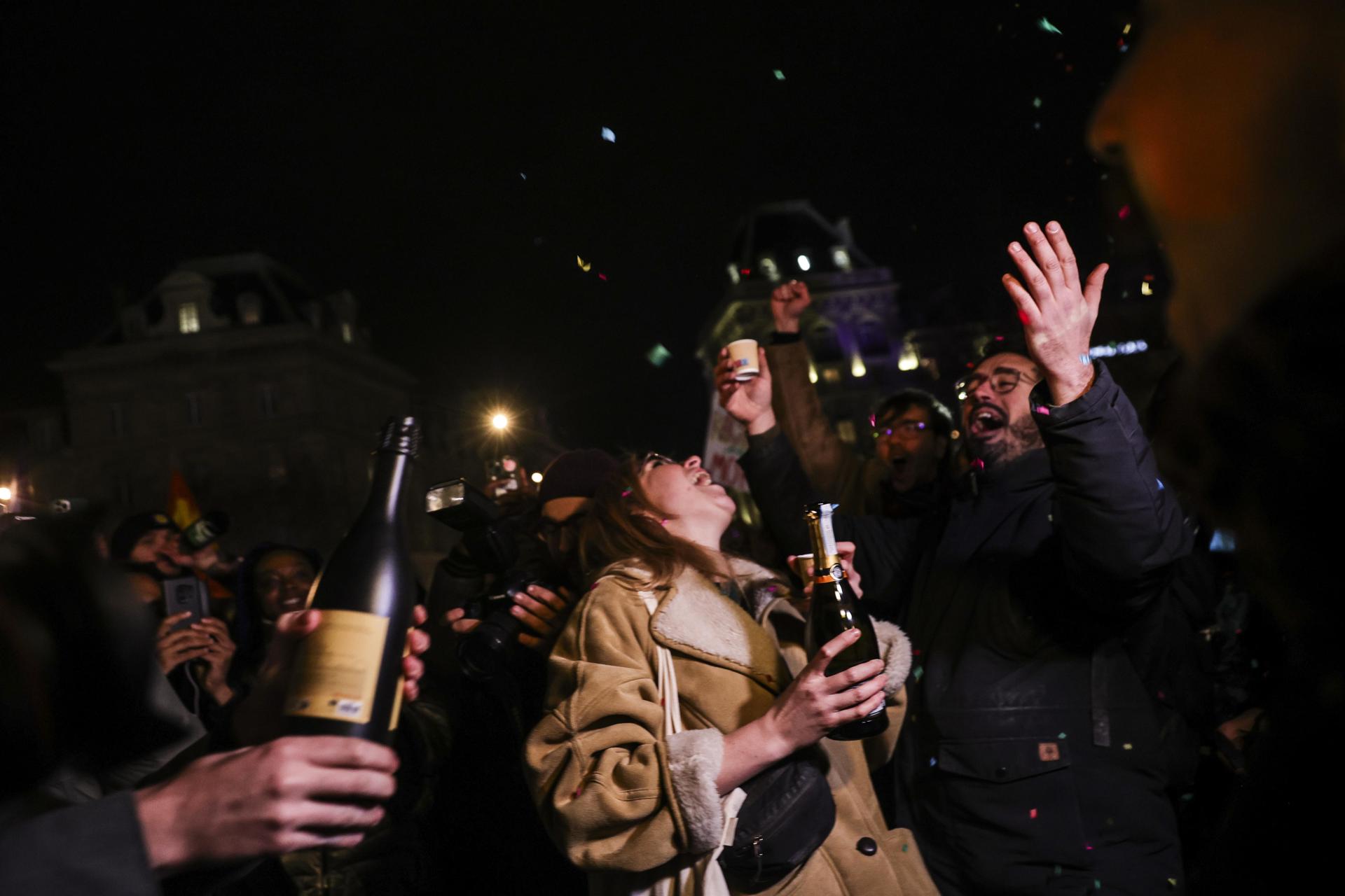 La gente abre botellas de champán durante una reunión en la Place de la Republique en París, Francia, el 7 de enero de 2025, para celebrar la muerte de Jean-Marie Le Pen, el ex líder del Frente Nacional. El político francés Le Pen falleció el 7 de enero de 2025 a los 96 años. EFE/EPA/Teresa Suarez
