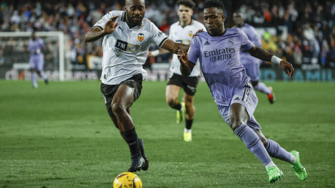 Foto de archivo del delantero brasileño del Real Madrid Vinicius jr (d) y el defensa francés del Valencia Dimitri Foulquier (i). EFE/Biel Aliño
