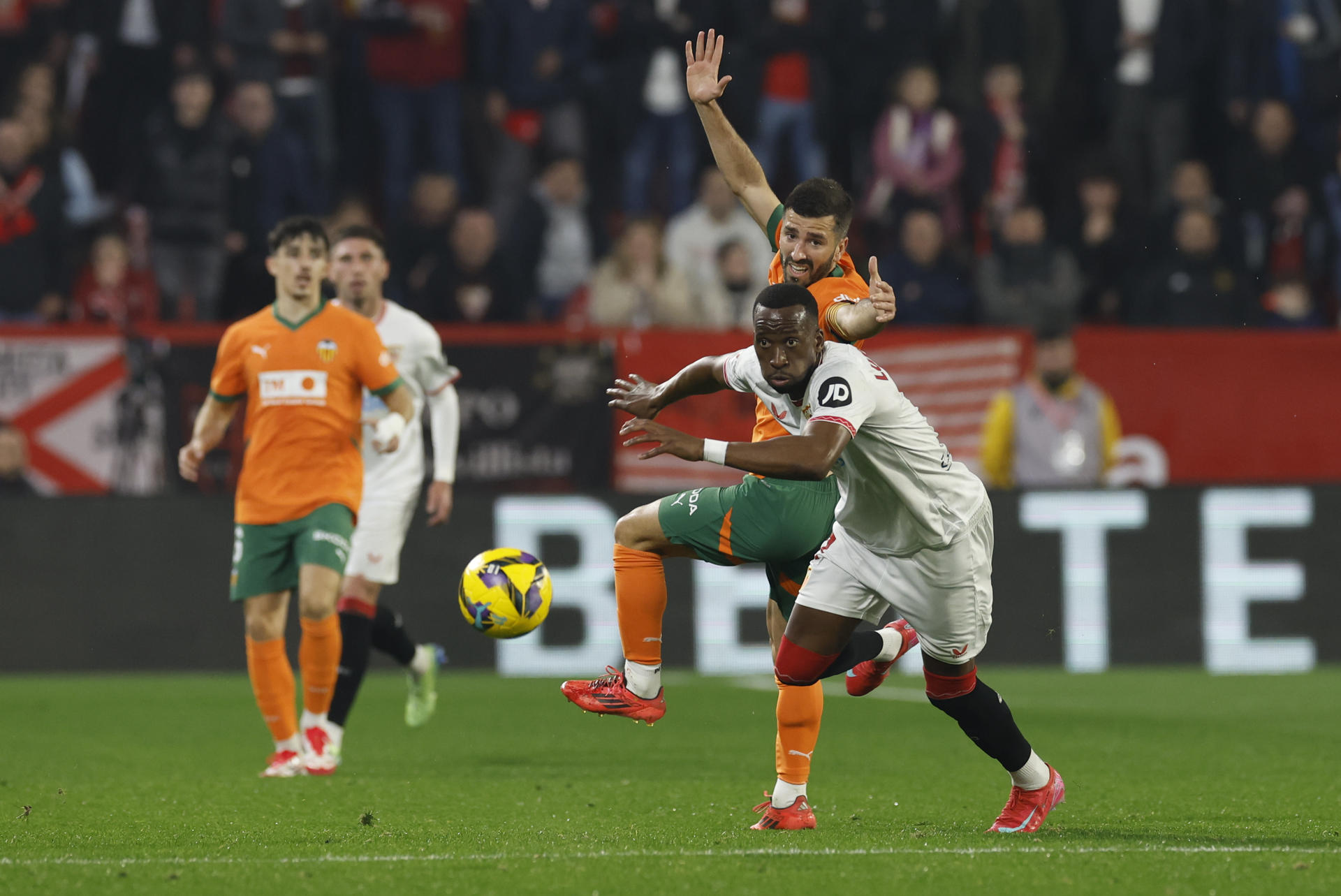 El centrocampista belga del Sevilla Dodi Lukebakio (d) lucha con José Gayá, del Valencia, durante el partido de la jornada 19 de LaLiga que Sevilla FC y Valencia CF disputan este sábado en el Ramón Sánchez-Pizjuán, en Sevilla. EFE/Julio Muñoz
